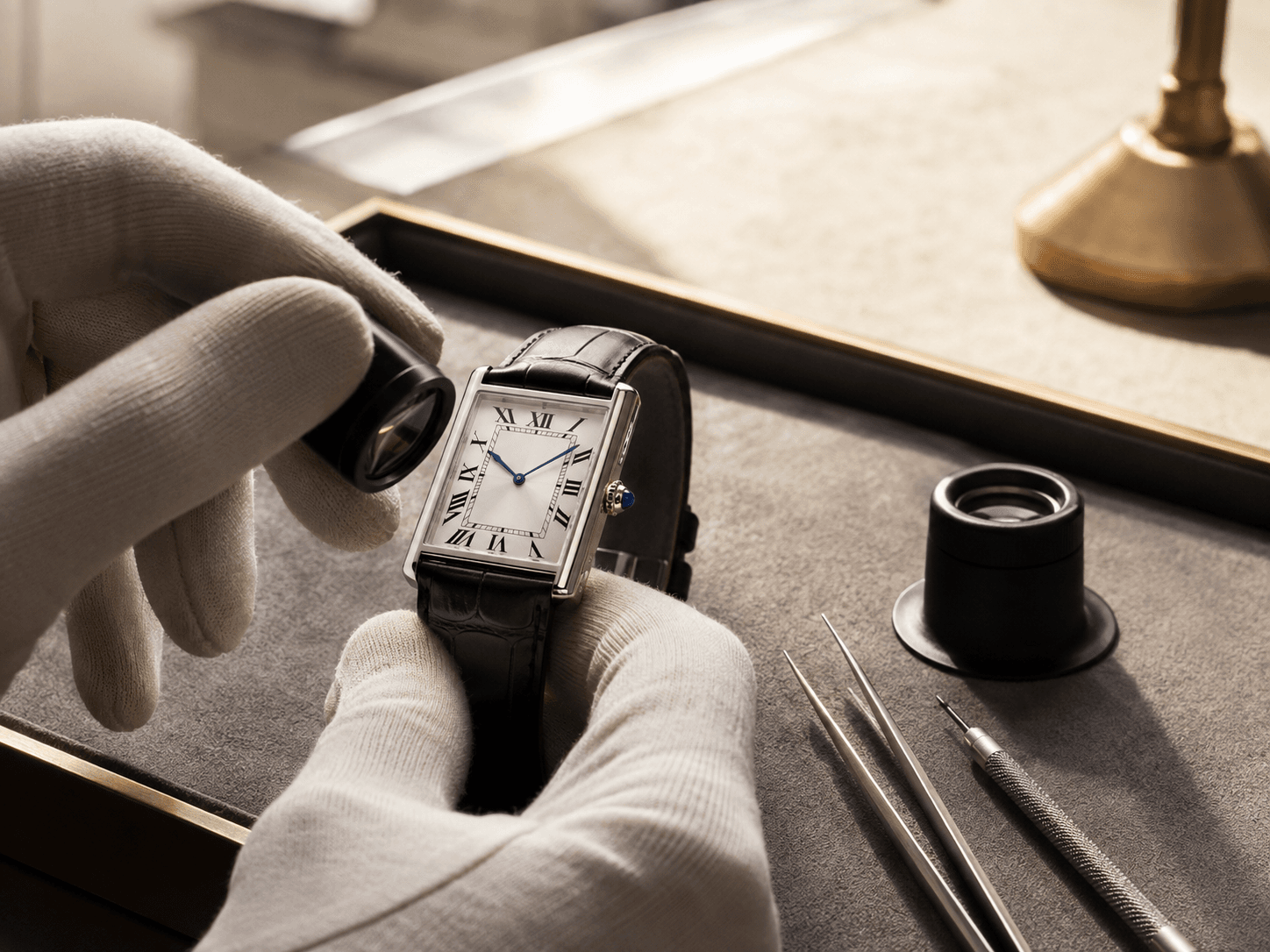 A Cartier watch inspected with a loupe during an InstaGold evaluation